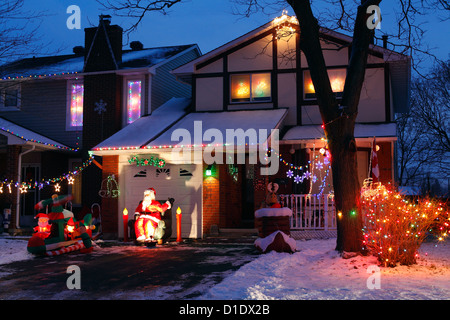 A Canadian House Lavishly Decorated With Christmas Lights On The Outside  And Garden At Night. Stock Photo