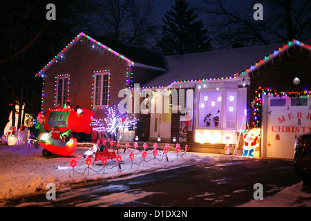 A Canadian House Lavishly Decorated With Christmas Lights On The Outside  And Garden At Night. Stock Photo