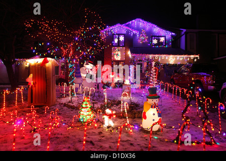 A Canadian House Lavishly Decorated With Christmas Lights On The Outside  And Garden At Night. Stock Photo