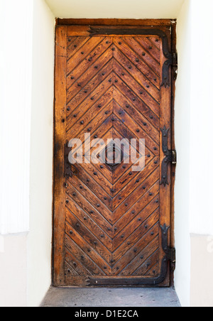 Old wooden door with rusty hinges and handle Stock Photo