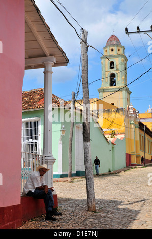 A cowboy takes a rest in the shade in front of San Francisco de Asis church, Trinidad de Cuba, Cuba. Stock Photo