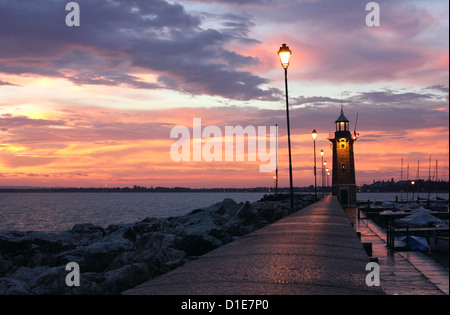 Amazing Sunrise at Desenzano del Garda with the marina and the old Lighthouse. Stock Photo