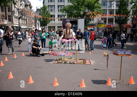 Netherlands. Amsterdam. Leidseplein Square. Street entertainer. Yoga levitation trick. Stock Photo