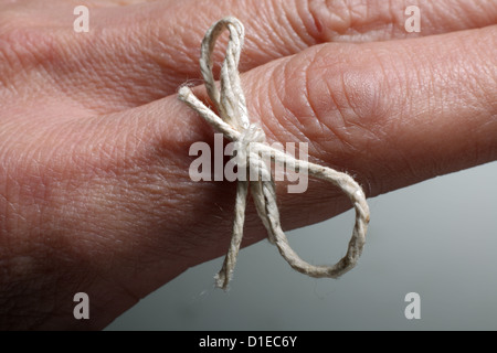 String tied around a mans finger as an aid to memory. Stock Photo