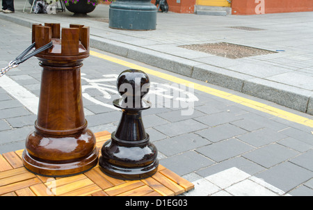 huge chess figures outdoor near bicycle path. People fun entertainment play object in street Stock Photo