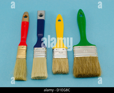 different colors and size paint brushes on blue background. Stock Photo