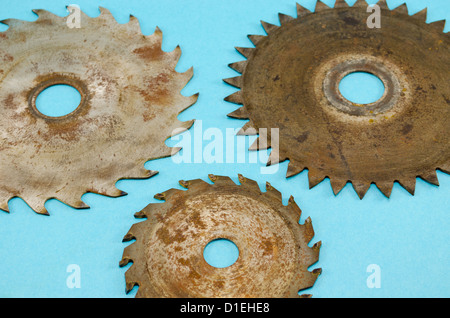 three circular saw disks parts with different blades closeup on blue background Stock Photo