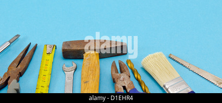 various construction work tools hammer meter chisel wrench pincers screwdriver brush bit on blue background. Stock Photo