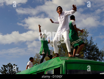 Children dancing on roof of school bus, part of the Float Parade for the 2012 Heilala Festival. Nuku'alofa, Tonga Stock Photo