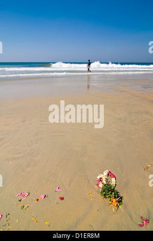 Vertical close up of flower garlands washed up on the beach after puja (prayers) at the beach in Varkala, Kerala. Stock Photo