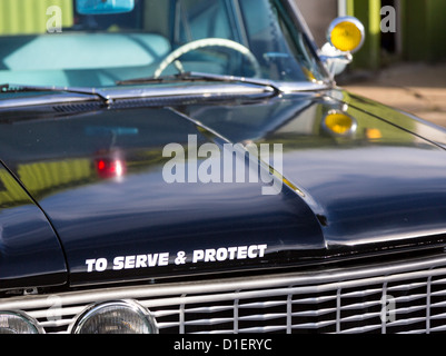 Vintage police car with detail focus on hood and reflections of warning lights in paint Stock Photo