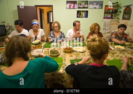 Horizontal portrait of Western tourists eating Indian meal using fingers instead of cutlery and banana leaves instead of plates. Stock Photo