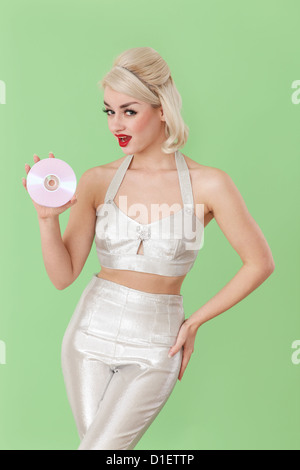 Woman in silver outfit holding  a CD Stock Photo