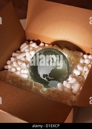Glass globe protected styrofoam by in a brown packing box Stock Photo