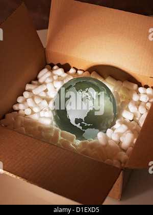 Glass globe protected by styrofoam in a brown packing box Stock Photo