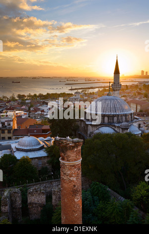 Setting sun behind the Sokollu Mehmet Pasha mosque minaret and historic Dervish ruins on the Marmara Sea Istanbul Turkey Stock Photo