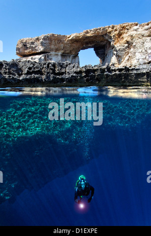 Split shot half and half with diver and rock arch Azure window in the Mediterranean Sea near Gozo, Malta Stock Photo