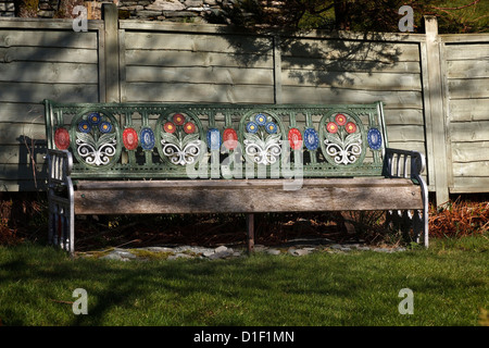 Old ornate floral painted cast iron metal and wooden garden bench seat, Cumbria, England UK Stock Photo