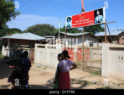 People walk past the office of the Burmese political party National League for Democracy in Bagan, Myanmar, 29 October 2012. At the entrance, photos of party head and Nobel Peace Prize laureate Aung San Suu Kyi and her father Aung San, former Commander of the Independence Army View, are seen. Photo: Rolf Zimmermann Stock Photo