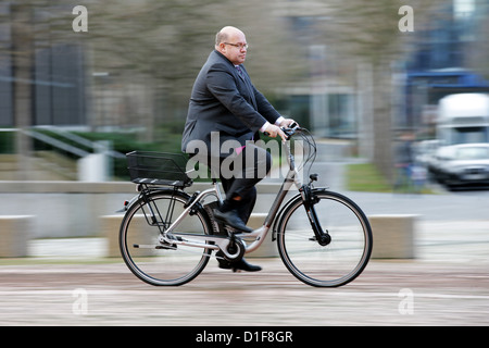 German environmental minister Peter Altmaier (CDU) rides an office e-bike at the ministry department in Bonn, Germany, 18 December 2012. Photo: ROLF VENNENBERD Stock Photo