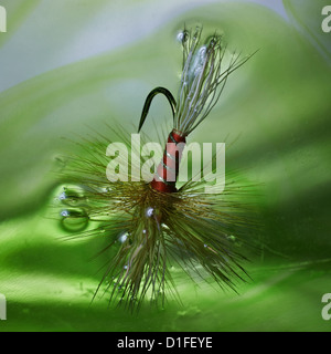 Wulff red artificial Fishing fly used in angling in extreme close shot in water Stock Photo