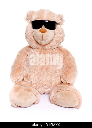 Teddy bear sitting over white background wearing black sunglasses Stock Photo