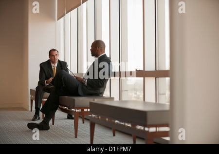 Businessmen talking in waiting area Stock Photo