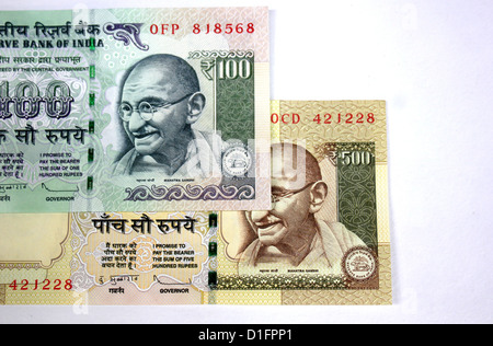 India currency A hundred rupee note over a five hundred rupee note in white background 100 and 500 Stock Photo