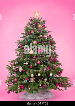 Decorated Christmas tree isolated on cute pink background Stock Photo