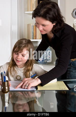 Young teenager girl doing her homework with her mother's help Stock Photo