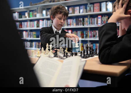 Secondary high school pupil boys playing chess in School library, education, learning, London, UK. Stock Photo