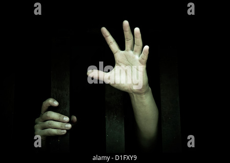 man's hand stretch out from prison bars Stock Photo