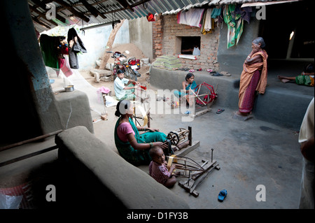 Women in communal back yard of weaving village, spinning silk thread, Vaidyanathpur weaving village, Orissa, India Stock Photo