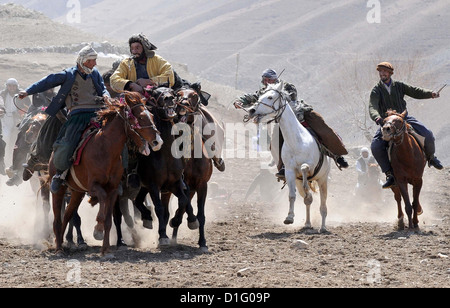 Afghan Chapandaz or Buzkashi players fight for a calf carcass during a Buzkashi game in Paryan District, Afghanistan April 7, 2012. Buzkashi is the national game of Afghanis. The goal is to grab the carcass of a goat or calf, clear it of the other players and get it into a target circle to attain points. Stock Photo