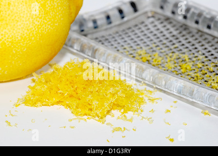 Small heap of grated lemon zest with a whole lemon and grater Stock Photo