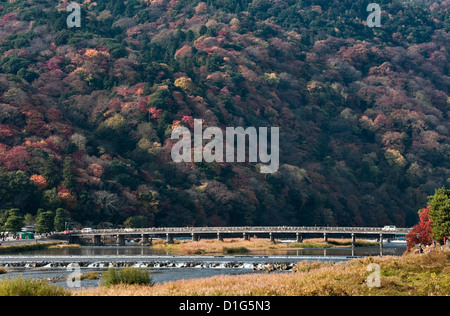 A view of the 'Moon Crossing Bridge' (Togetsukyo) on the Katsura river below Mt Arashiyama, in autumn - Arashiyama, Kyoto, Japan Stock Photo