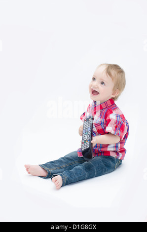 A cute baby holding a remote in his hands Stock Photo