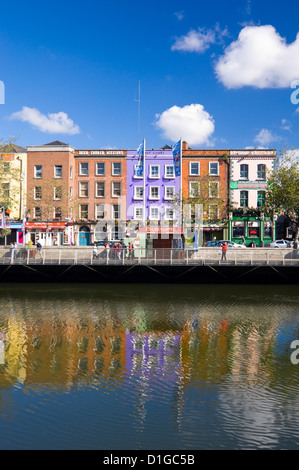 Vertical view of the colourful buildings along Batchelor's Walk reflected in the River Liffey in Dublin on a sunny day. Stock Photo