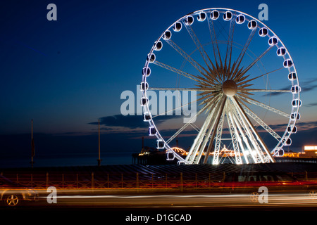 Traffic whizzes by the Brighton Wheel at night, leaving light trails in its wake. Stock Photo