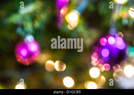 Blurred out of focus Christmas tree lights and baubles, abstract twinkling lights background. Stock Photo
