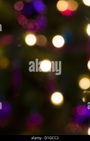 Blurred out of focus Christmas tree lights and baubles, abstract twinkling lights background. Stock Photo