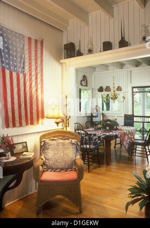 EATING AREAS Summer country home dining area flag hung on wall wicker chair wood walls quilt tablecloth country style charming Stock Photo