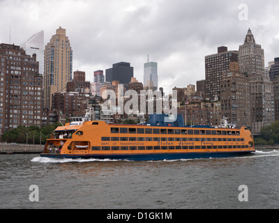 The Staten Island Ferry MV Andrew J. Barberi makes its way down the East River New York City with the buildings of Manhattan Isl Stock Photo