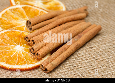 Cinnamon sticks and dried orange on hessian Stock Photo
