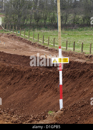 goalpost and warning sign of overhead power line lines cable cables health and safety new road building construction site uk Stock Photo