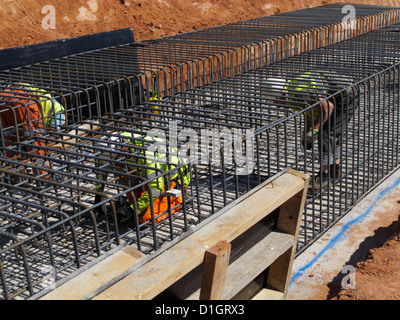 Steel fixer tying reinforcement bars in a bridge foundation base construction building site civil engineering UK Stock Photo
