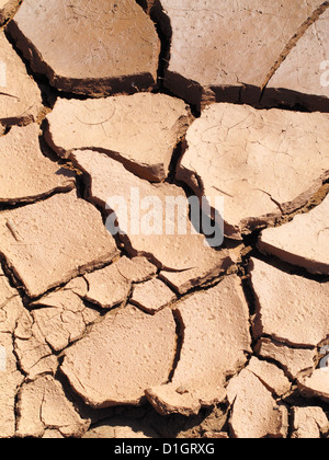 Close up detail of red dried out cracked mud on the bed of a reservoir lake pond in a drought Stock Photo