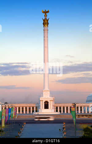 Bus passing KazakYeli monument (Kazakh Country) at dusk, Astana, Kazakhstan, Central Asia, Asia