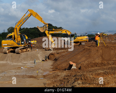 Tacked excavators working on new road construction site UK Stock Photo