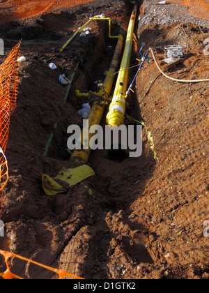 Newly laid High pressure yellow polythene gas main pipe in trench undergoing testing with pressure gauge in UK Stock Photo